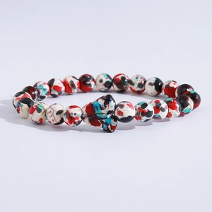 Detail of colorful beads with a butterfly charm on a multi-color beaded bracelet