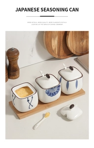 Detail view of Japanese ceramic seasoning jars with blue floral patterns and wooden base