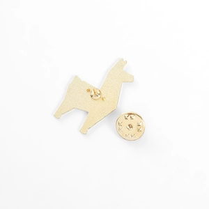 Close-up of golden metal animal brooch back with butterfly clutch and textured finish
