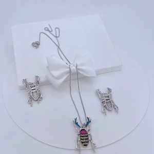Silbernes Käfer-Schmuckset mit bunten Zirkonia, bestehend aus Halskette und Ohrringen auf Ständer