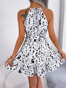 Back view of a white leopard print halter neck dress featuring tiered ruffle hem details