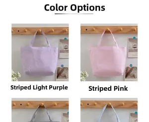 Detail view of striped canvas tote bags in light purple and pink on wooden hooks