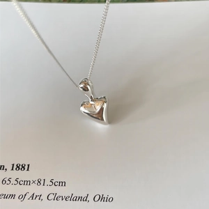 Macro shot of 925 sterling silver irregular heart pendant with high mirror polish
