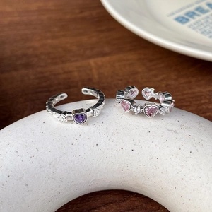 Detail of adjustable 925 silver rings with purple heart stone and pink gemstone row