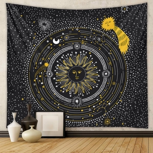 Detail of bohemian black tapestry with gold sun and star patterns on grey textured wall