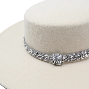 Detail of beige felt boater hat with shimmering rhinestone band and wool texture