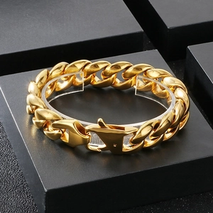 Detail of chunky gold Cuban link bracelet for men on a black matte display block