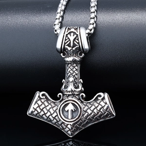 Macro detail of Viking Mjölnir pendant with vintage oxidized finish and Tiwaz rune symbol