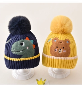 Detailed texture of thick ribbed knit baby winter hats with fluffy faux fur pom-poms