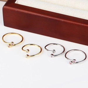 Detailed view of adjustable gold and silver rings with cubic zirconia on display