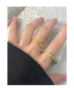 Close-up of gold star rings with crinkle texture on a vintage book background
