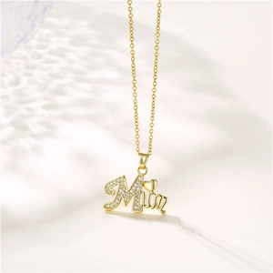 Gold stainless steel MOM necklace with cubic zirconia pendant and heart on white background