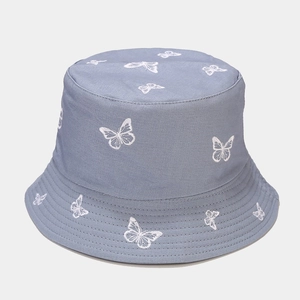 Close-up of white butterfly embroidery on a blue cotton bucket hat for sun protection