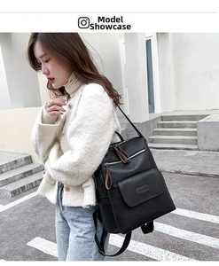 Close-up of black PU leather backpack with clear texture and stylish metal brand logo