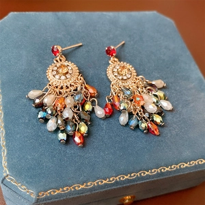 Bohemian floral earrings with colorful crystal tassels on blue velvet jewelry box