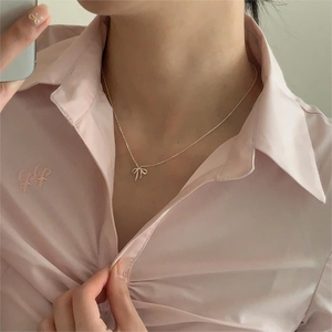 Elegant 925 sterling silver bow pendant necklace shown on a model with a soft pink background