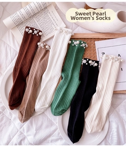 Detailed view of women's ribbed cotton socks with pearl floral embellishments in soft colors