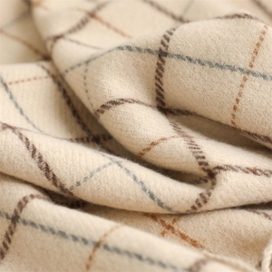 Macro detail of soft beige and brown plaid cashmere-like scarf with thick woven texture