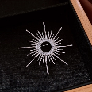 Macro shot of silver sunburst star brooch with pave set cubic zirconia on black velvet