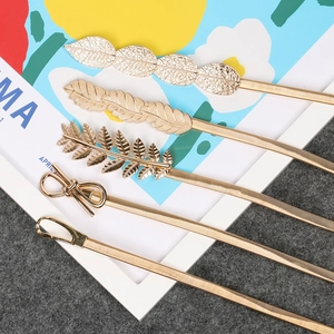 Detail of five gold elastic metal belts with leaf and bow buckles for dresses