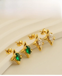 Detailed view of 18k gold plated star earrings with emerald and clear zircon stones