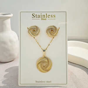 Detailed macro view of gold-plated stainless steel jewelry set with spiral hollow patterns
