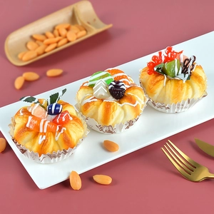 Macro detail of artificial fruit cakes with kiwi and berries on a white ceramic plate
