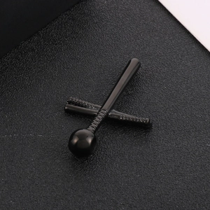 Detail of polished black stainless steel cross pendant on textured black background
