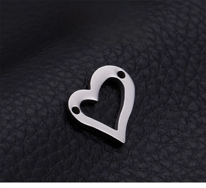 Macro detail of heart-shaped hollow stainless steel connector with dual-hole for DIY jewelry