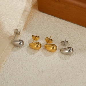 Polished stainless steel waterdrop earrings in gold and silver finish on silk background