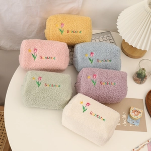Cute tulip fleece makeup bags in multiple colors with Sunshine embroidery on white desk