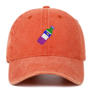 Close-up of vintage washed coral baseball cap featuring detailed bottle embroidery