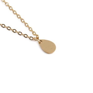 Collier en acier inoxydable plaqué or avec pendentif goutte sur fond blanc pur