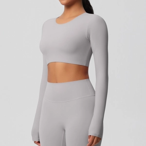 Détail de l'ensemble de yoga gris clair montrant le legging taille haute et le haut court manches