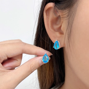 925 silver teardrop earrings with blue zircon stones shown on a professional model