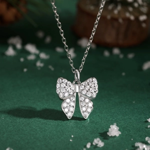 Macro shot of a silver butterfly necklace pendant with zircon pavé for a festive gift set