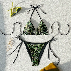 Flat lay of green leopard print bikini set with neck ties and decorative sunglasses