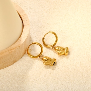 Detailed close-up of golden stainless steel hoop earrings with 3D cactus shaped pendants