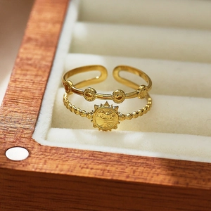 Macro detail of gold-plated open ring featuring star pattern and beaded double layers