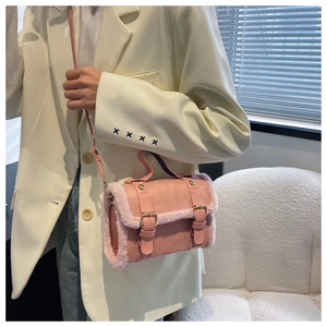 Close-up of pink faux leather bag with soft plush fur trim and stylish metal buckles