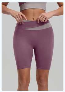 Detail of high-waisted yoga shorts featuring a bicolor contrast and crisscross waist design
