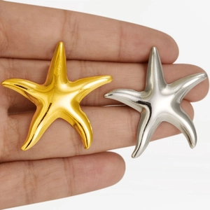 Starfish earrings in 18k gold and silver stainless steel shown on hand in detail