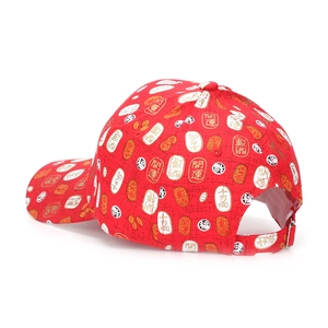 Détail de la boucle métallique sur casquette rouge avec caractères chinois de chance