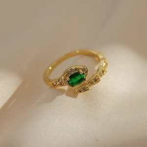 Close-up of 18K gold plated ring with green oval gemstone and micro-pave crystals