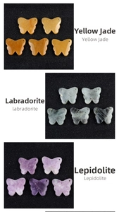 Detailed view of carved butterfly pendants in yellow jade, labradorite and lepidolite
