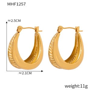 Detail view of gold U-shaped earrings with textured lines, measuring 2.5cm by 2.1cm