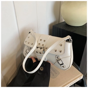 Detailed view of punk style white shoulder bag with silver rivets and metal buckles