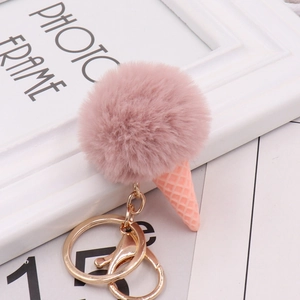 Close-up of cute pink pompom ice cream keychain with golden metal clasp and resin cone