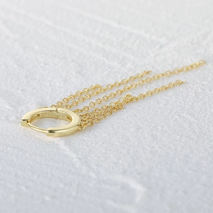 Detailed close-up of golden S925 sterling silver hoop earring with long tassel chains