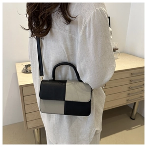 Dettaglio della borsa a tracolla patchwork a scacchi in ecopelle nera e beige